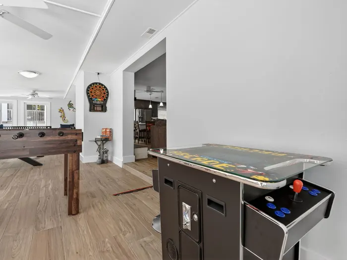 Game room with foosball table, arcade cabinet and dartboard