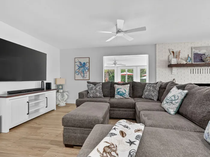 Open living room with sectional sofa, large TV and fireplace